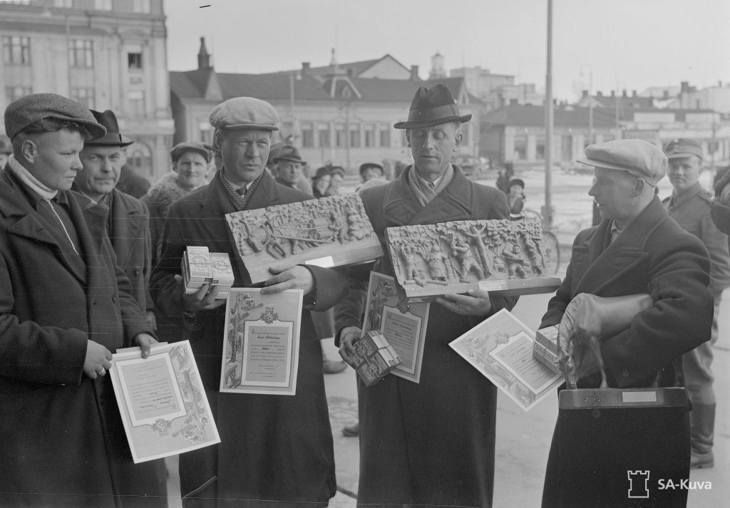 Valtakunnan metsäjuhla Kuopiossa 23.4.1943. Sarjojen ensimmäisen palkinnon saajat: Jenny Pitkänen (äärimmäisenä vasemmalla), Kali Härkönen, Eino Sivonen ja Väinö Nordström. SA-kuva. 